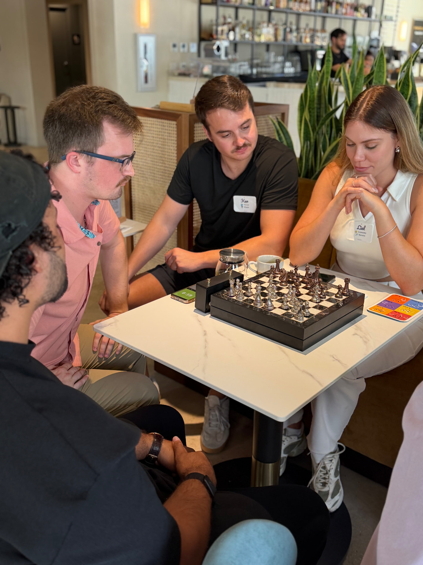 Guests playing chess and talking at a Convive experience in Miami